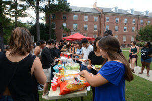 Students wait in line, outside of Alexander and Turlington residents hall, for carne asada and hamburgers at the LatinX Cookout on Friday, Sept. 15, 2015.